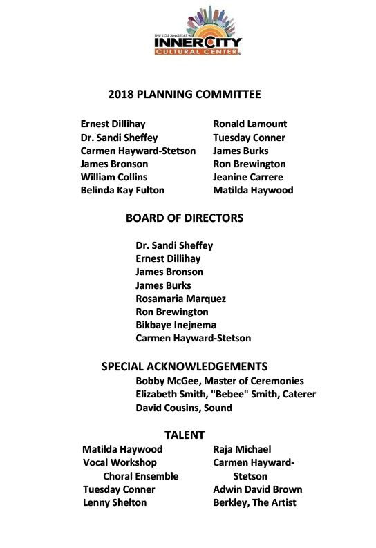 Portrait of a smiling woman wearing pearls and a dark outfit.