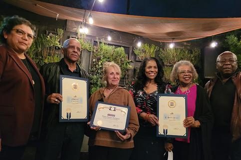 Group of people holding certificates, smiling.